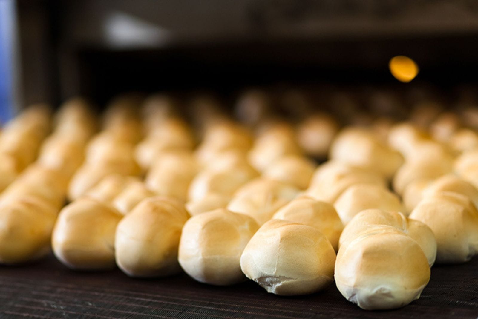 dinner rolls coming out of a commercial oven