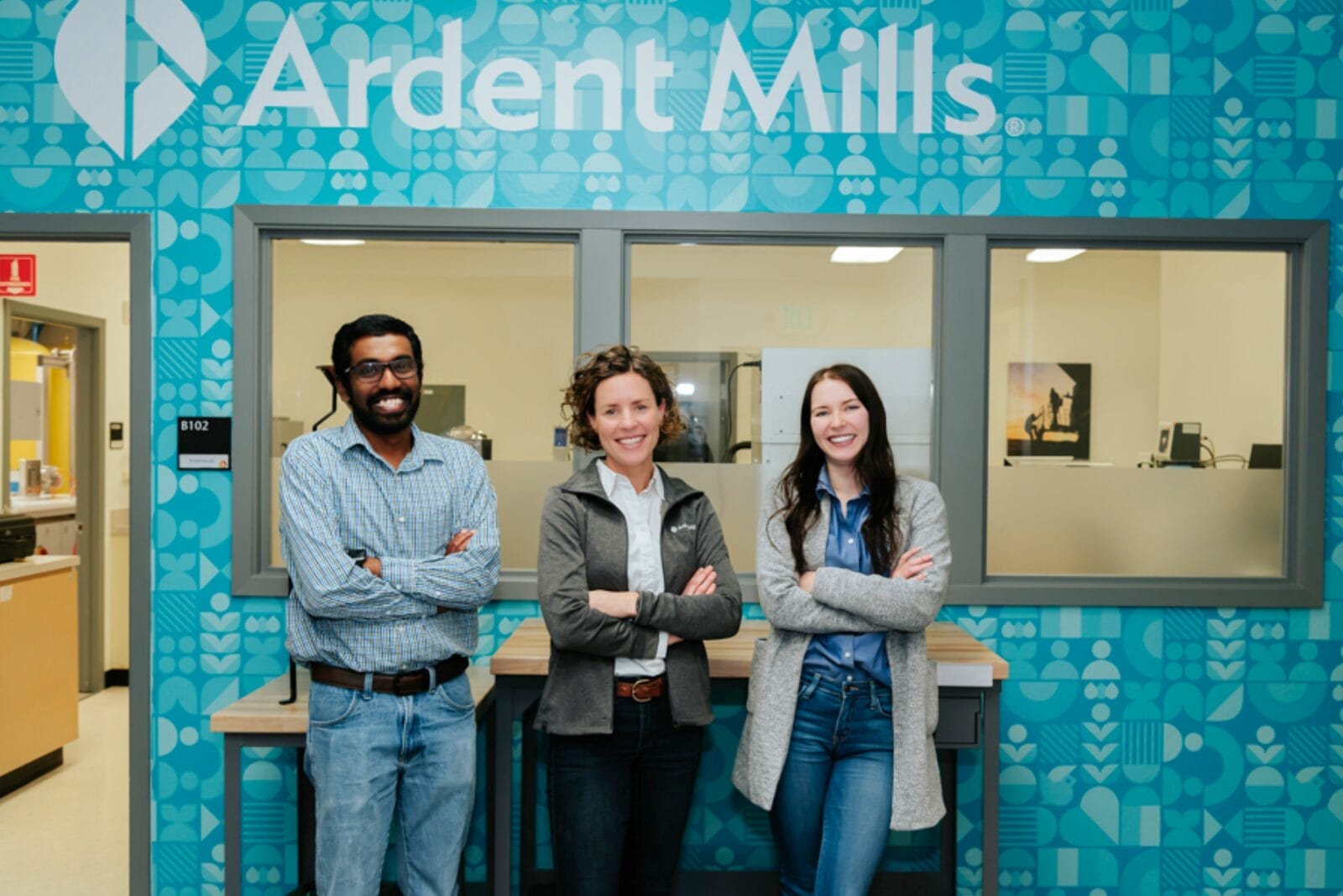Three Ardent Mills employees standing with crossed arms in front of entrance to new Innovation Center