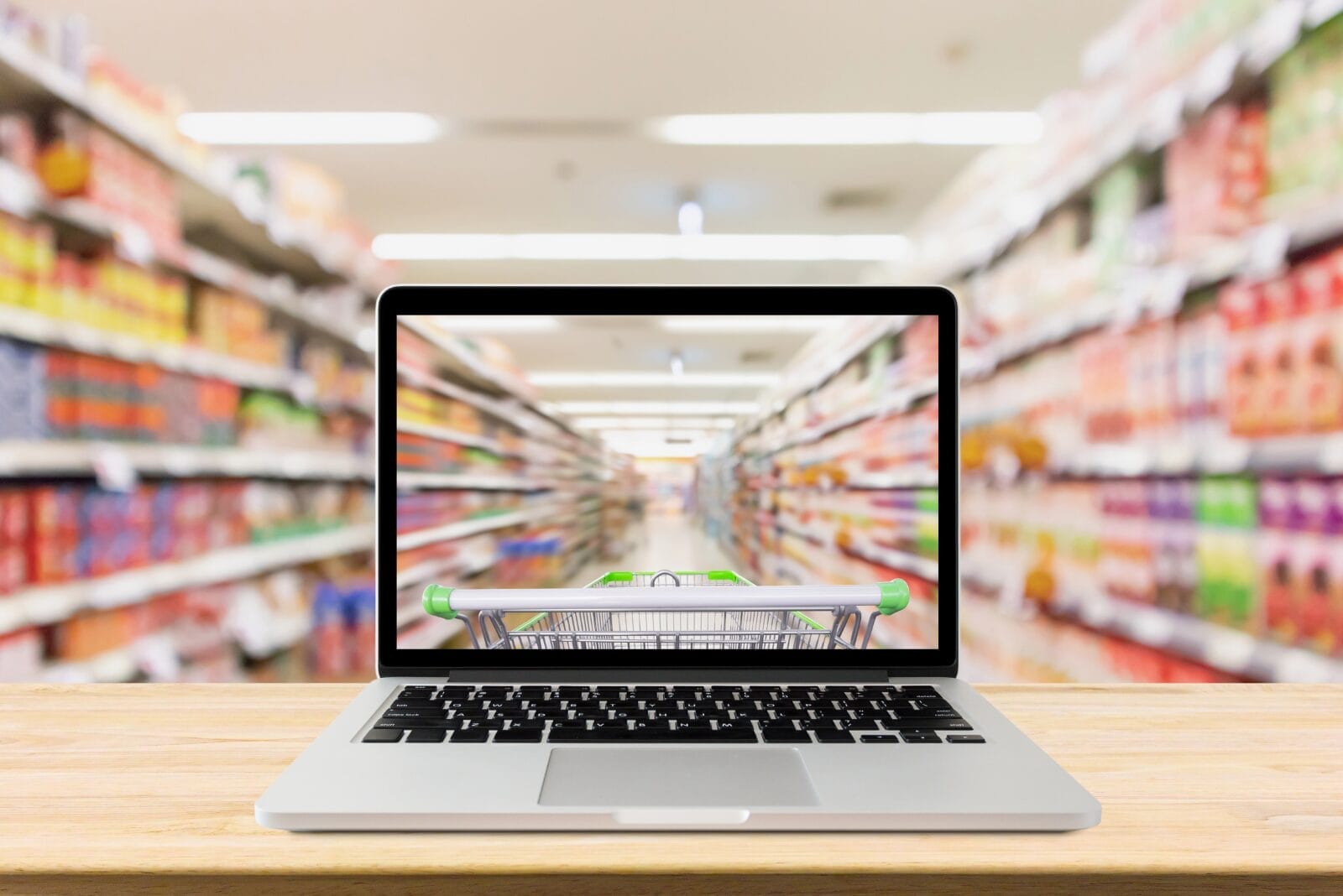 Symbolic imagery of online grocery shopping - Laptop in grocery store shows aisles and grocery cart