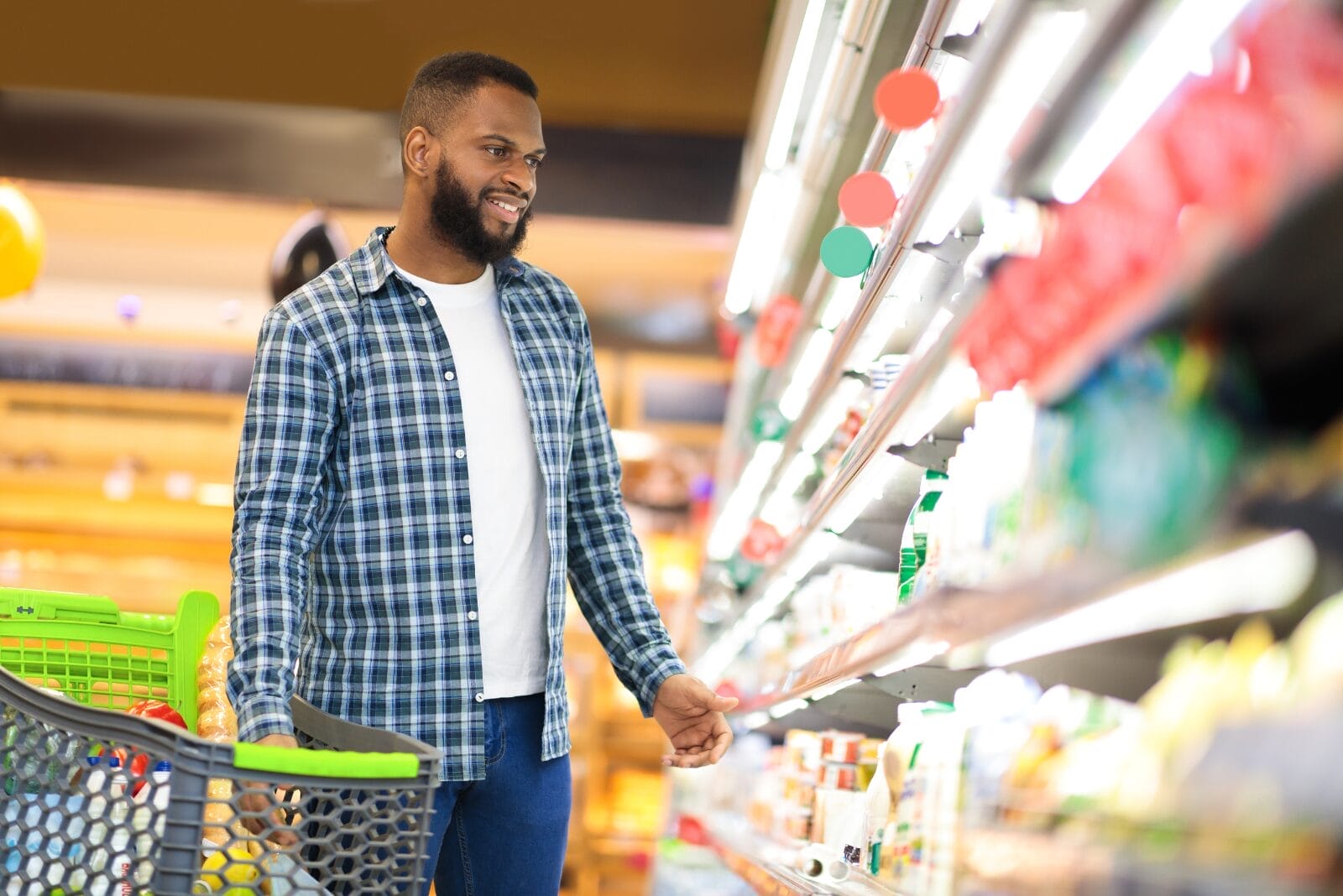 Man shopping in grocery store with cart.