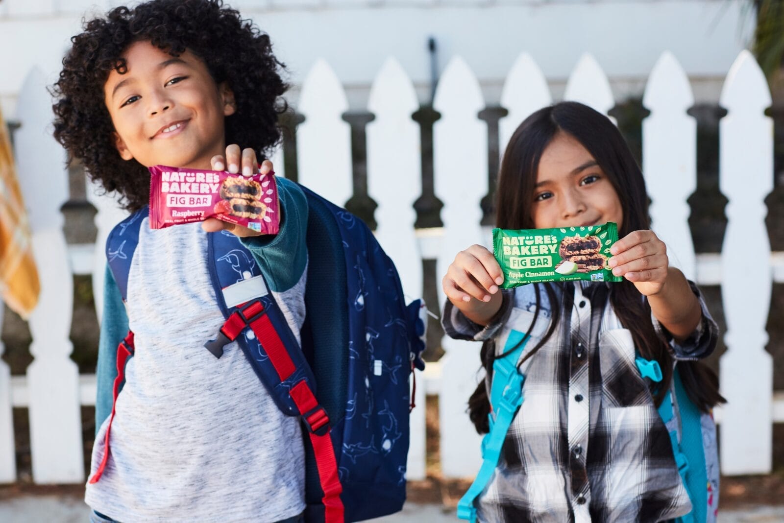 Children with backpacks holding Nature's Bakery products