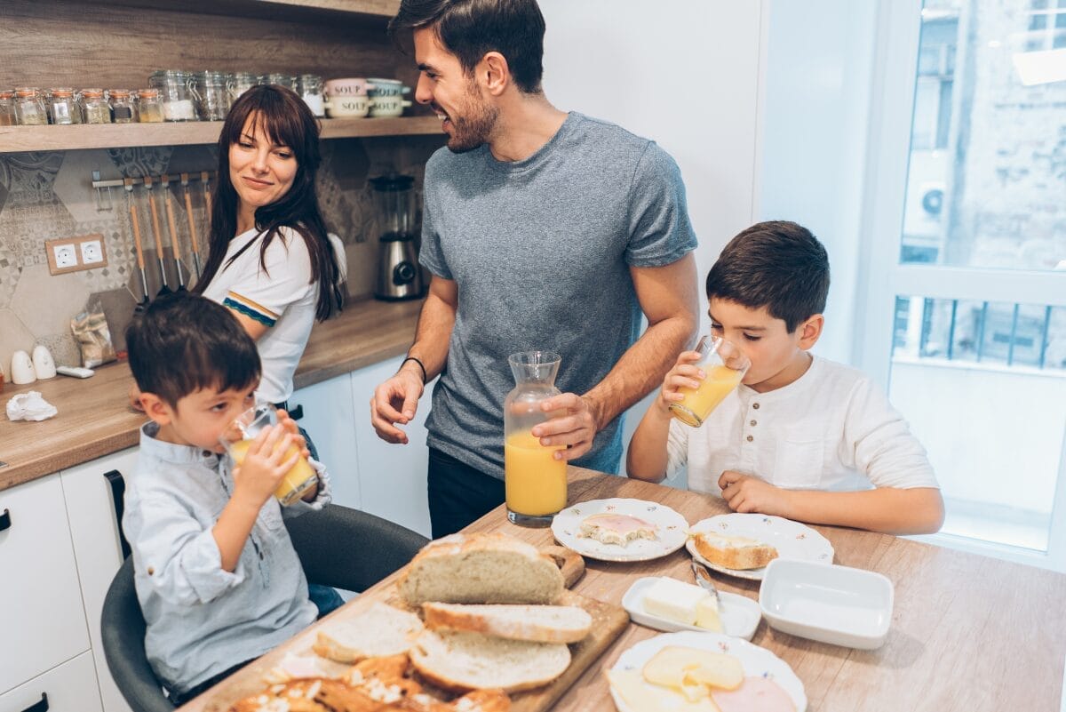 FAMILY OF FOUR AROUND A TABLE WITH BREAD