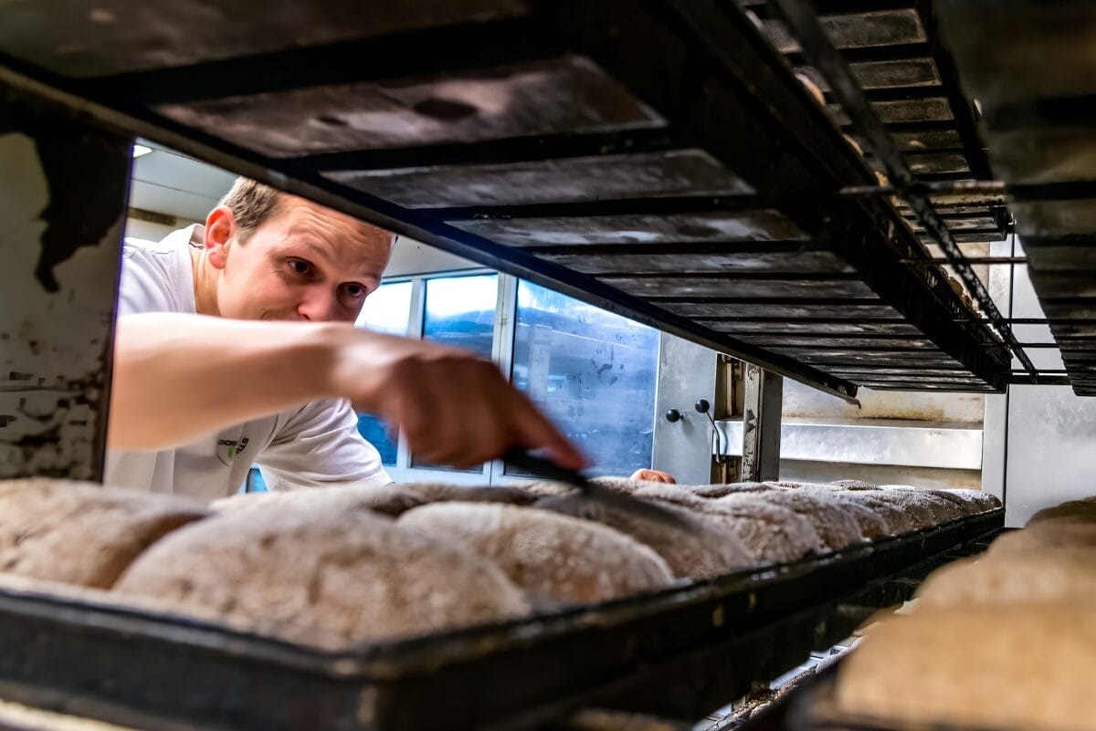 person scoring bread