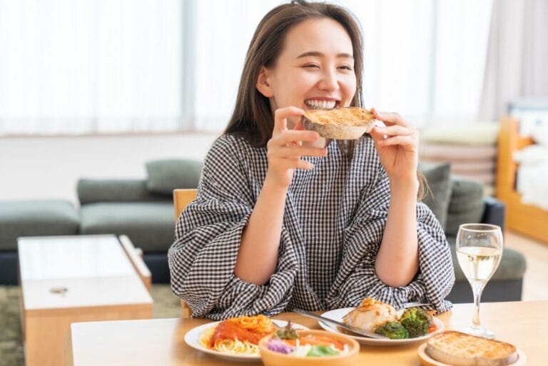 Woman with black and white long sleeve shirt eating toast