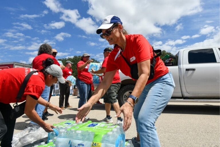 H-E-B employees passing cases of water bottles