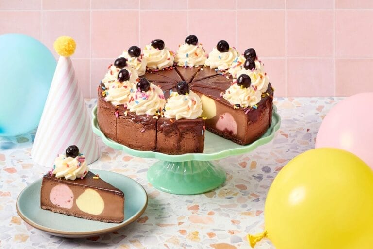 Eli's Cheesecake Cheesecake Sundae on green cake tray with party decorations