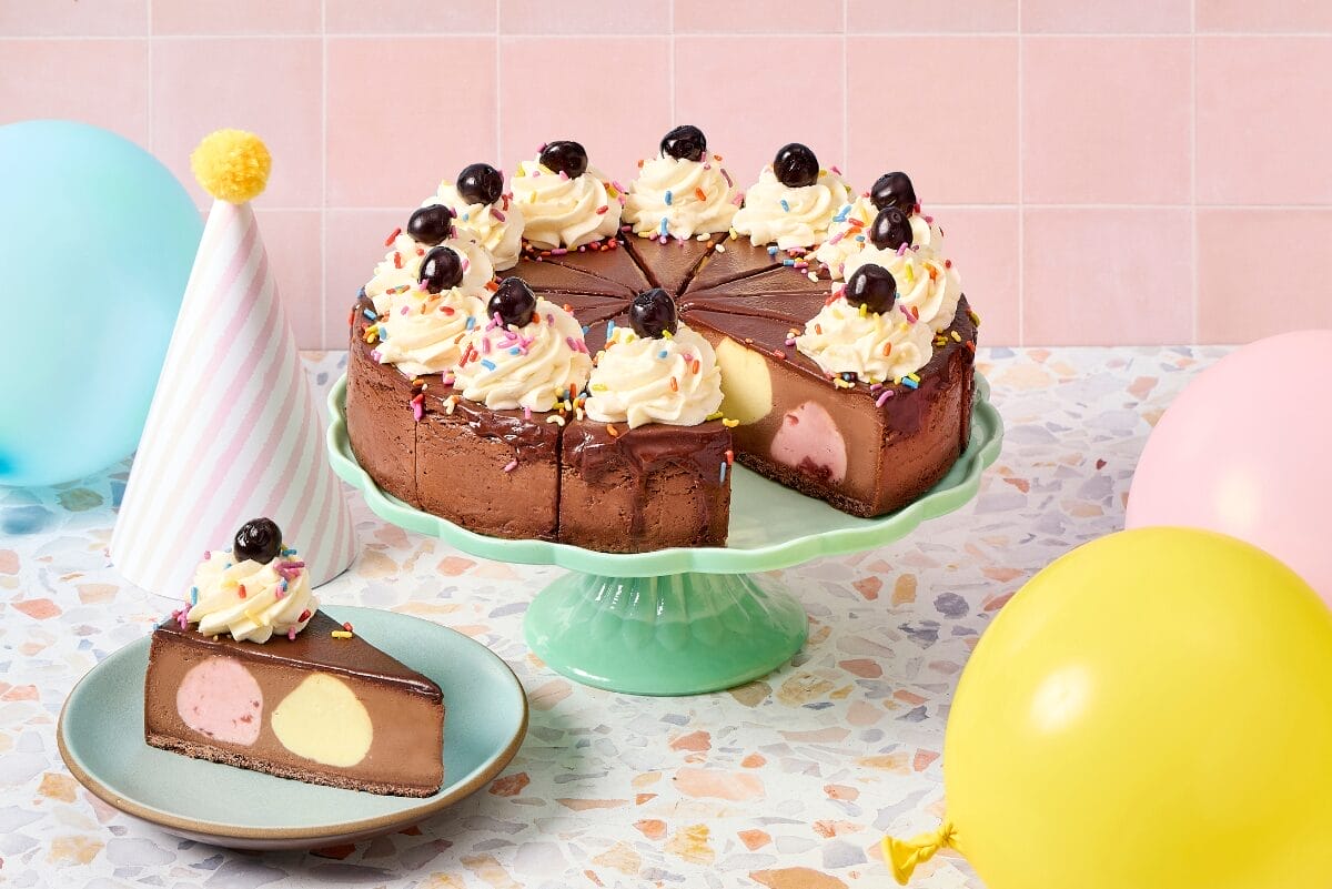 Eli's Cheesecake Cheesecake Sundae on green cake tray with party decorations