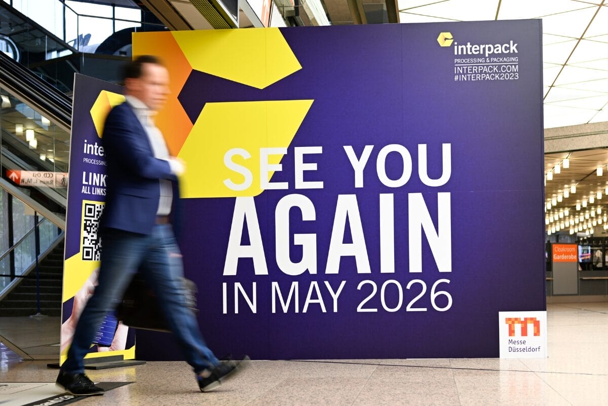 Man walking in front of sign from interpack reading "SEE YOU AGAIN IN MAY 2026"