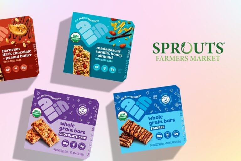 Boxes of All In Food snack bars on pink-orange background with Sprouts Farmers Market logo