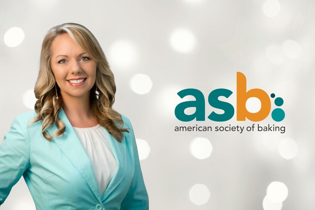 Kathy Sargent in mint blazer and white shirt with American Society of Baking logo on silver sparkle background