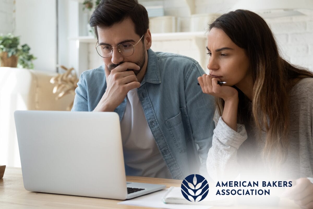Man and woman looking at laptop with American Bakers Association (ABA) logo in corner