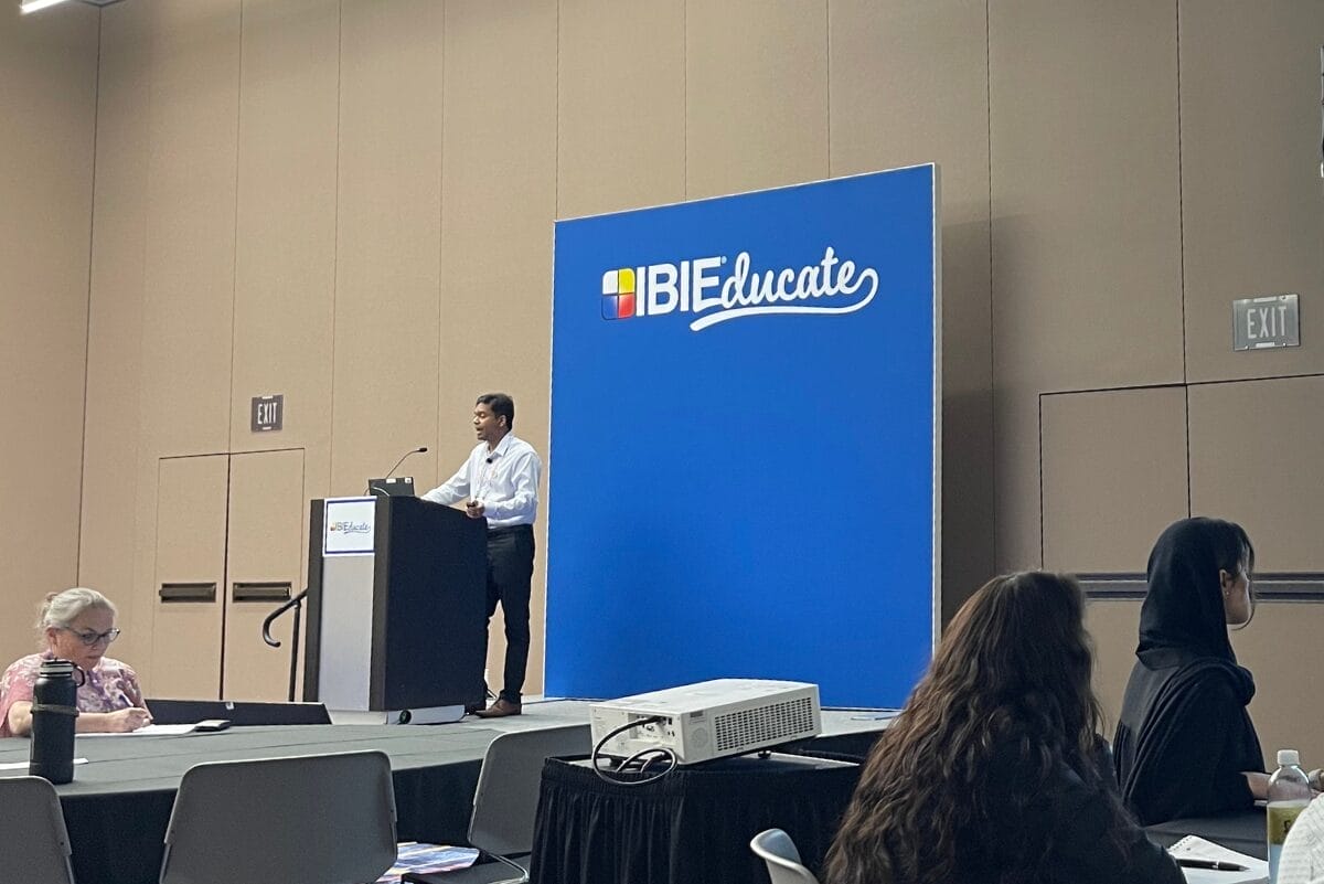 Speaker presenting at IBIE 2025 on enzymes and sustainability